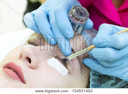 Woman on the procedure for eyelash extensions, eyelashes lamination