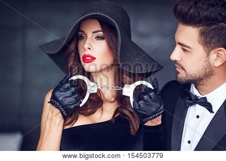Sexy milf woman holding handcuffs for lover indoor bdsm