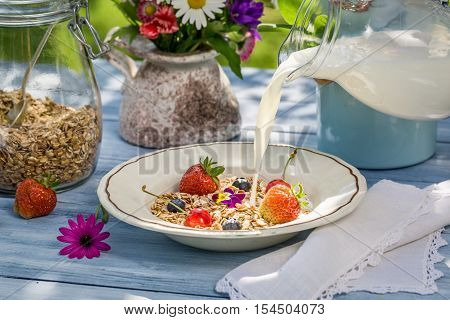 Oatmeal with fruit and milk on old wooden table
