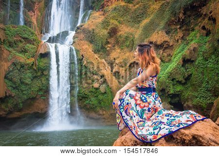 Beautiful waterfall in Morocco. Back woman beautiful dress looking fall Ouzoud Grand Atlas. Exotic nature North Africa