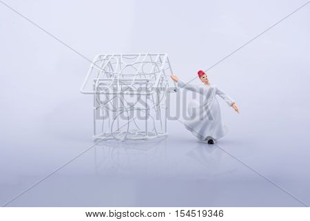 Sufi dervish and a little metal house on a white background