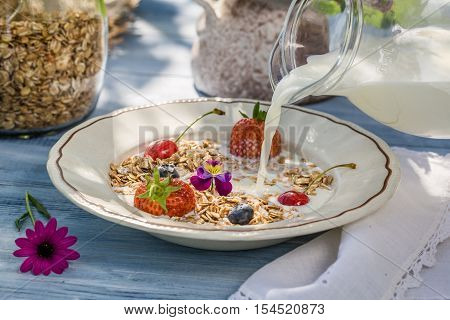 Oatmeal with fruit and milk on old wooden table