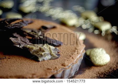 Chocolate tart decorated with dark chocolate and gold dust.Chocolate pie.Selective focus.