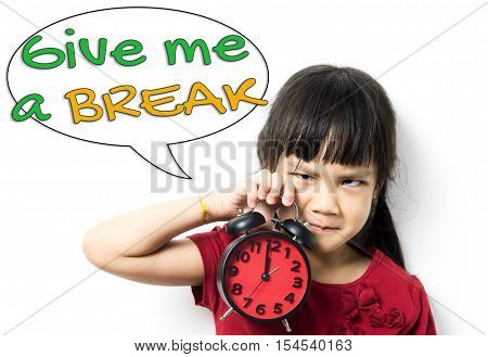 Angry Asian baby girl is holding a clock asking for a lunch break. An unhappy little girl telling you to Give Me a Break. Asian Student is stressed out and asking for a Break.