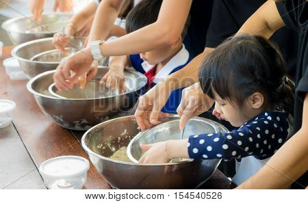 Asian kid and family is learning how to make ice cream in a cooking class.