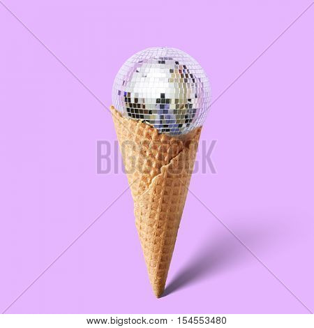 Waffle cornet with disco ball isolated on purple