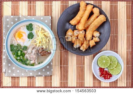 Rice porridge with mined pork and chicken lever served with side dish as Patongko (deep-fried dough stick) and spicy sour filling.