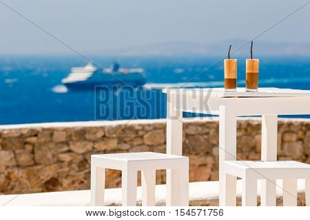 Coffee latte on wooden table with sea background