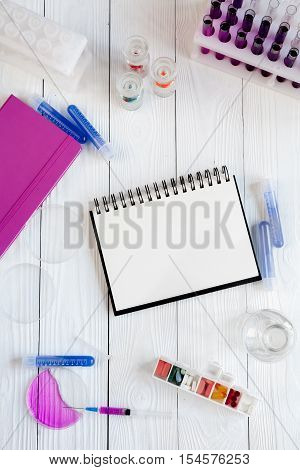 medical student working place with blank open notebook at wooden table top view
