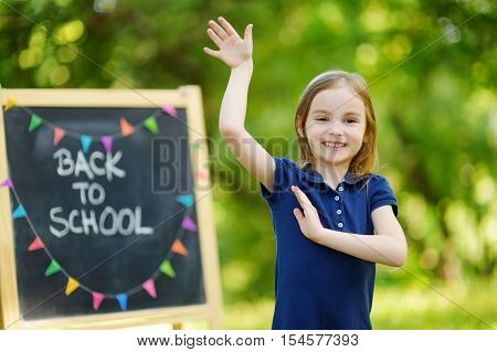 Very Excited Little Schoolgirl By A Chalkboard