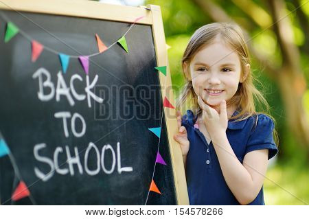 Very Excited Little Schoolgirl By A Chalkboard