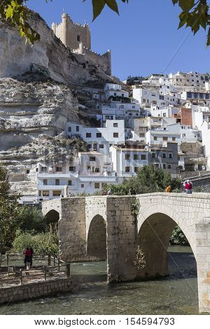 Alcala del Jucar Spain - October 29 2016: Roman bridge located in the central part of the town to its passage by the river Jucar at the top of mountain limestone is situated castle of Almohad origin of the century XII take in Alcala of the Jucar Albacete