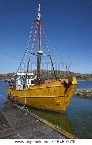 WEST POINT ISLAND, FALKLAND ISLANDS - OCTOBER 23, 2016: Converted trawler tied up on the jetty at the West Point Settlement on West Point Island in the Falkland Islands