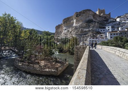 Alcala del Jucar Spain - October 29 2016: Roman bridge located in the central part of the town to its passage by the river Jucar at the top of mountain limestone is situated castle of Almohad origin of the century XII take in Alcala of the Jucar Albacete