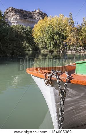 Alcala del Jucar Spain - October 29 2016: Jucar river boat of recreation in small lagoon in the central part of the town at the top of mountain limestone is situated castle of Almohad origin of the century XII take in Alcala of the Jucar Albacete province