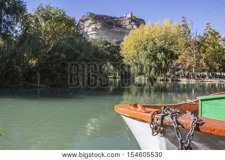 Alcala del Jucar Spain - October 29 2016: Jucar river boat of recreation in small lagoon in the central part of the town at the top of mountain limestone is situated castle of Almohad origin of the century XII take in Alcala of the Jucar Albacete province