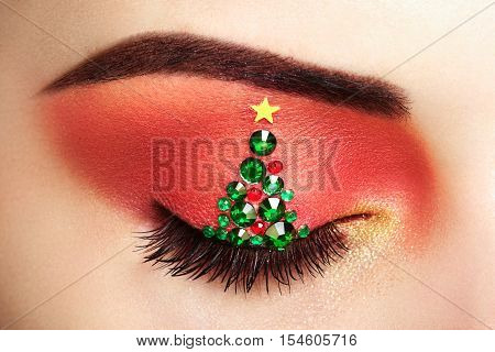Eye girl makeover christmas tree. Winter christmas makeup. Beauty fashion. Eyelashes. Cosmetic Eyeshadow. Makeup detail. Creative woman holiday make-up