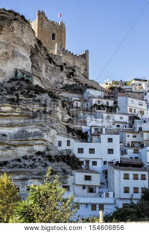 Alcala del Jucar Spain - October 29 2016: Side view of the village on top of limestone mountain is situated Castle of the 12TH century Almohad origin take in Alcala of the Jucar Albacete province Spain