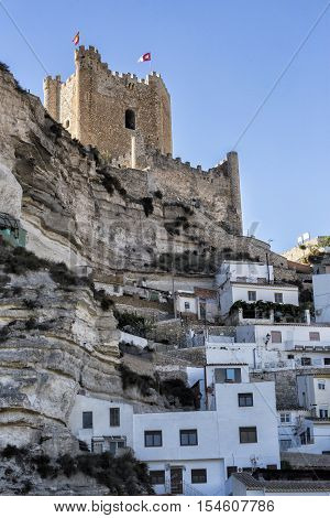 Alcala del Jucar Spain - October 29 2016: Side view of the village on top of limestone mountain is situated Castle of the 12TH century Almohad origin take in Alcala of the Jucar Albacete province Spain