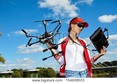 A woman is standing and holding drone