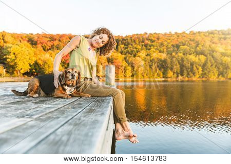 Woman And Dog Relaxing On The Dock