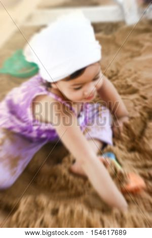 de-focused close up Asian little girl playing on sand