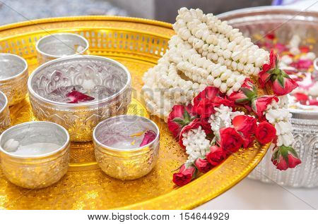 Thai garland Flowers and Water with jasmine and roses corolla in bowl on golden tray (Use for Songkran festival in Thailand)