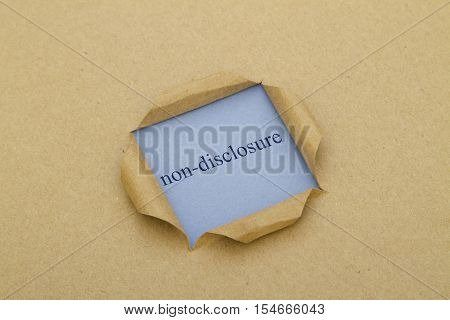 Non-Disclosure word written under torn paper .