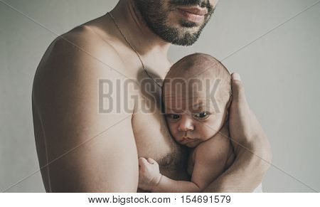 Portrait of loving father with baby at home. Man with baby. Young man holding with little baby. Sepia Toned