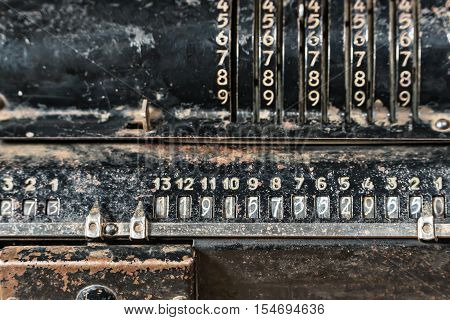 Old rusty mechanical retro black calculator close-up as background