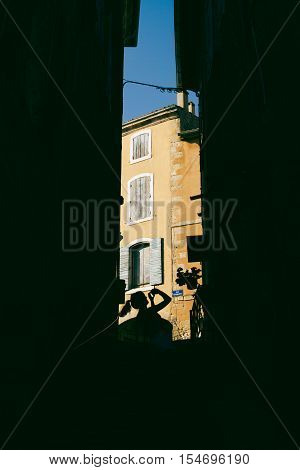 Silhouetted girl taking travel photos in french village