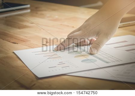 Close-up of business man hands pointing at turnover graph while discussing it