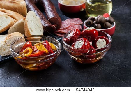 Spanish Tapas With Slices Jamon Serrano And Grilled Pepper. Also Olives, Salami, Pickled Onions, And