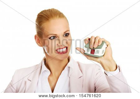 Aggresive business woman crushing small house