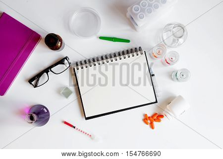 doctor workplace with blank open notebookat lab top view on white background