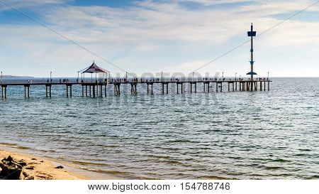 People on Brighton Jetty at sunset on a summer evening