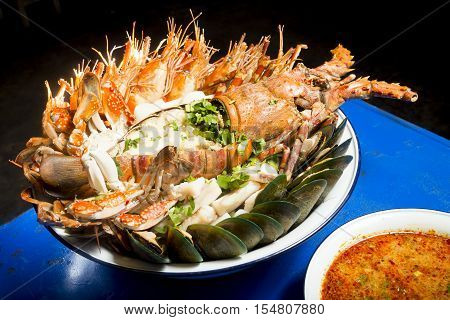 Various sea food with spicy soup on blue table