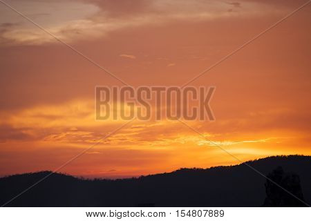 Orange sky after sunset behind the mountain