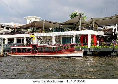Bangkok, Thailand - December 8, 2015: Tha maharaj shopping mall and restaurant on the Chao Phraya River. Local boat at the pier Bangkok Thailand.