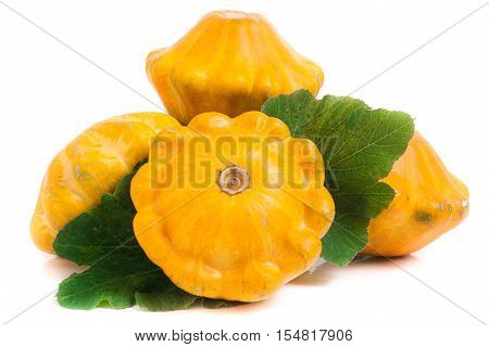 four yellow pattypan squash with leaf isolated on white background.