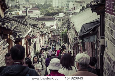 SEOUL - SOUTH KOREA - OCTOBER 21 2016 : A couple women wander through the traditional style houses of Bukchon Hanok Village in Seoul South Korea.