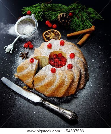 Christmas bundt cake with red berries on a black background