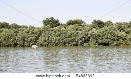 Danube River with Fishing Boat in the distance And Treeline in the Background