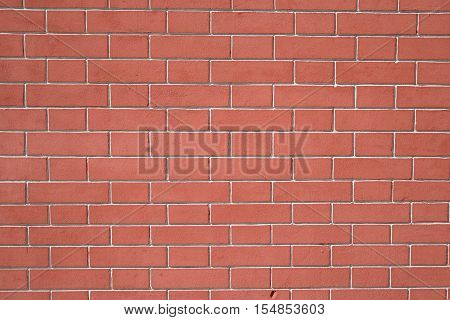 Wall of red bricks with grey cement