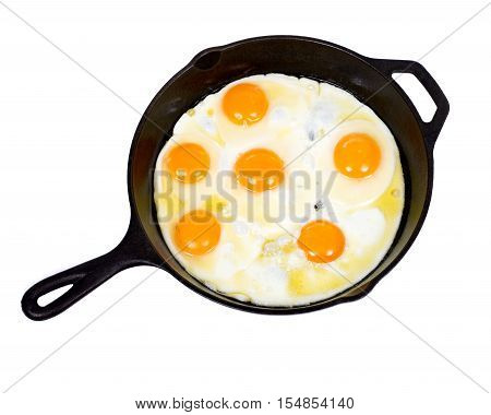 Fried eggs on cast iron skillet isolated on white background