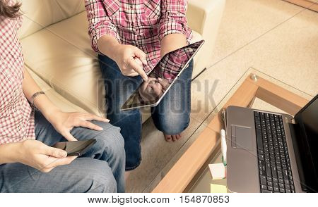 Business team working at a glass table. Computer and tablet on background. The finger on the screen a pencil in hand.