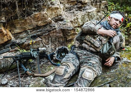 Wounded army ranger machine gunner in the mountains