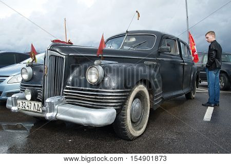 KRONSTADT, RUSSIA - SEPTEMBER 04, 2016: The young man considers the old Soviet government ZIS-110 car at an exhibition of a retro of cars