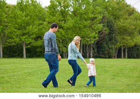 Happy Young Family  Together Outside In Green Nature.