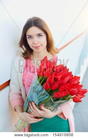 woman with a bouquet of red tulips
